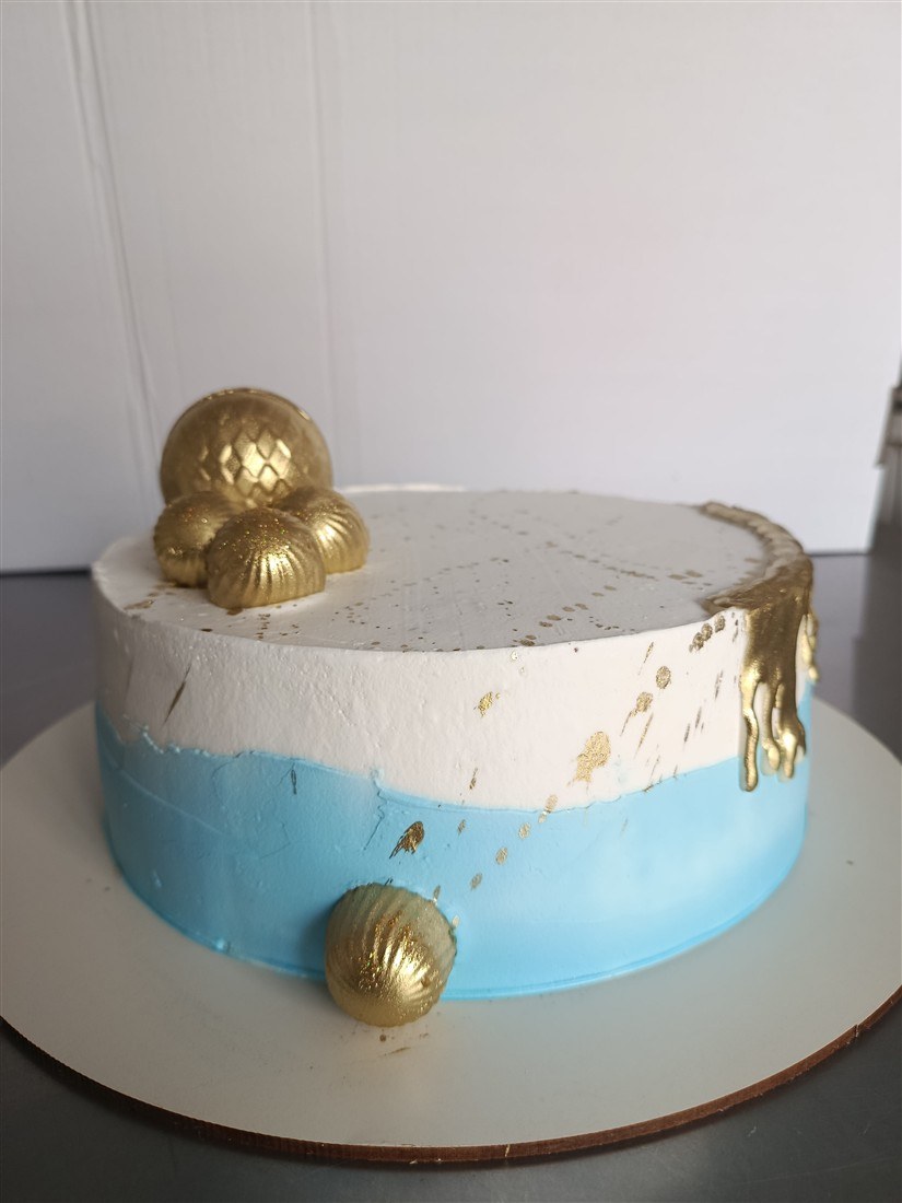 Bolo azul e branco com detalhes dourados